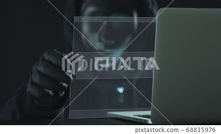 A hacker wearing black mask pulls DIGITAL ID tab from a laptop. Hacking concept A hacker wearing black mask pulls DIGITAL ID tab from a laptop. Hacking concept 68815976