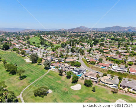 Aerial view of residential neighborhood surrounded by golf in green valley 68817534