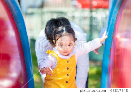Cute girl playing on a slide Cute girl playing on a slide 68817548
