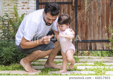 Adorable little 1 year old girl learning to walk Adorable little 1 year old girl learning to walk 68817803