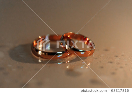 wedding rings lie on surface with drops of water wedding rings lie on surface with drops of water 68817816
