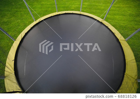 trampoline with big round mat on green lawn trampoline with big round mat on green lawn 68818126