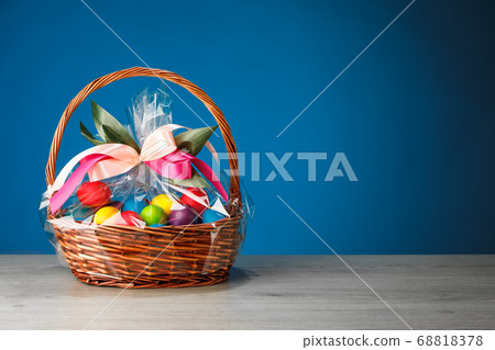 Easter gift basket with multicolor eggs, blue 68818378