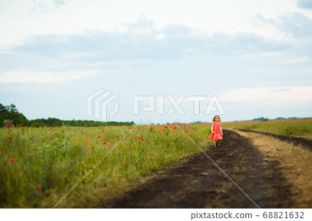 little girl goes in dirty dirt road after rain. 68821632