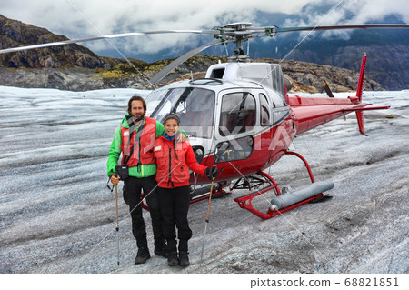 Alaska helicopter tour tourist couple on cruise excursion glacier hike activity in Skagway, Alaska, USA travel. Tourists portrait on helicopter ride in mountains landscape on summer vacation. 68821851
