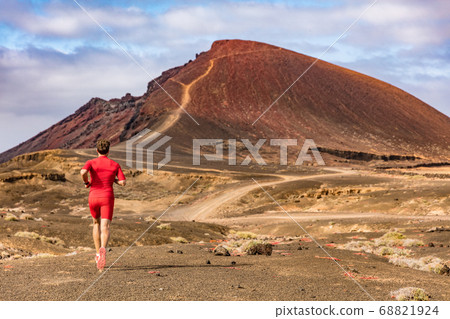 Sport and fitness athlete running on mountain trail, man active lifestyle. Man runner on long distance run through desert summer landscape. Sport and fitness athlete running on mountain trail, man active lifestyle. Man runner on long distance run through desert summer landscape. 68821924