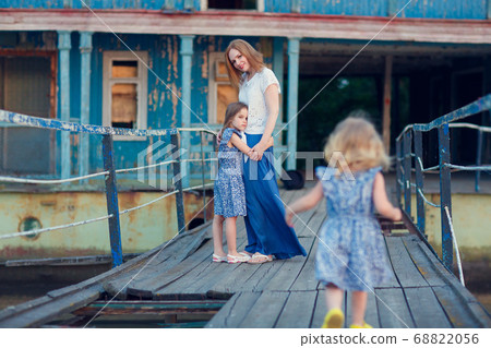 mom and kids in blue clothes standing old bridge 68822056