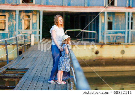 mom and kid in blue clothes standing old bridge 68822111