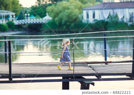 kid girl in blue clothes going old bridge 68822221
