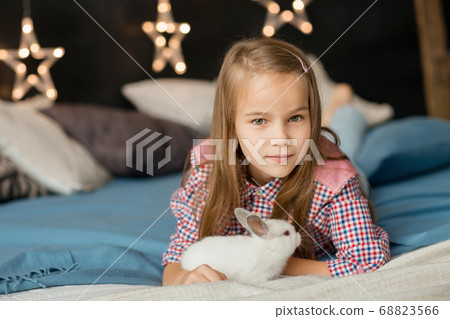Happy laughing little girl playing with rabbit 68823566