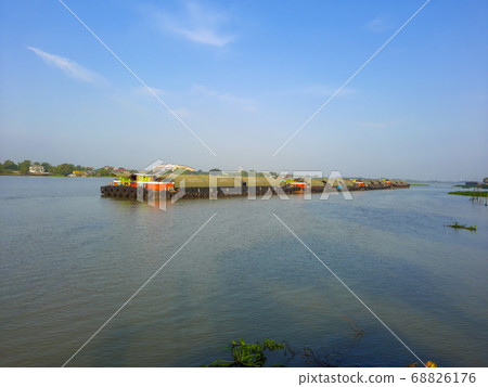 the ship is pushing a barge with sand along the the ship is pushing a barge with sand along the 68826176