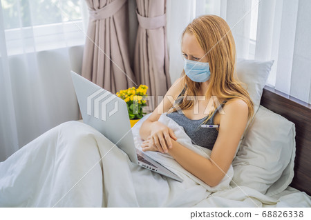 Woman lies in bed and has an online consultation with doctor GP 68826338