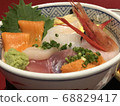 Bowl of rice topped with sashimi  68829417