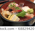 Bowl of rice topped with sashimi  68829420