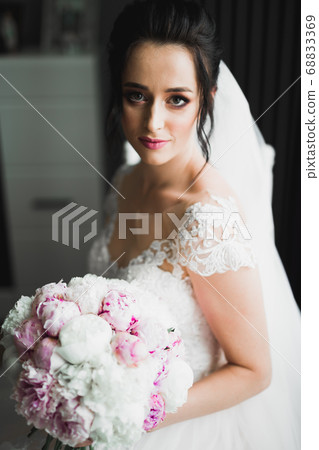 Bride holding big and beautiful wedding bouquet with flowers Bride holding big and beautiful wedding bouquet with flowers 68833369