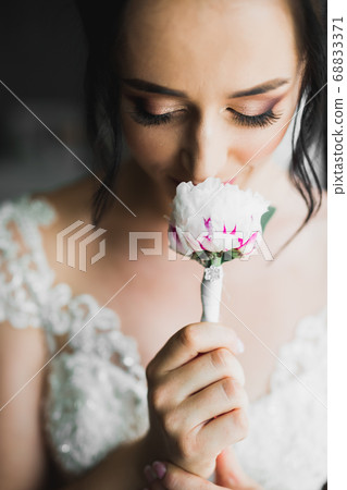 Luxury bride in white dress posing while preparing for the wedding ceremony Luxury bride in white dress posing while preparing for the wedding ceremony 68833371