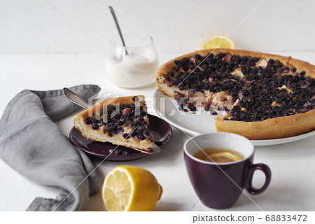 Summer cake with nightshade and apples, covered with beaten eggs on a light table.Healthy homemade food. 68833472