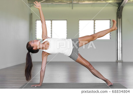 Yoga woman planking doing side plank leg lift core exercises in yoga class at fitness gym. Yoga woman planking doing side plank leg lift core exercises in yoga class at fitness gym. 68834804