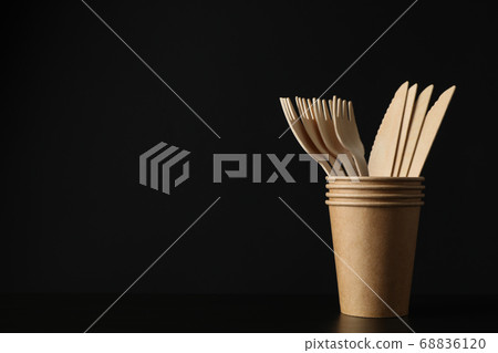 Eco - friendly cups with forks and knives on black Eco - friendly cups with forks and knives on black 68836120