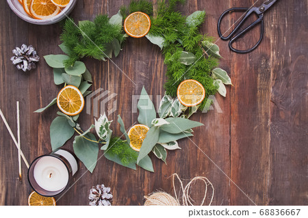 Hand made christmas wreath decorated with dry oranges on wooden table 68836667