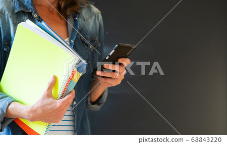 student with books and smartphone 68843220