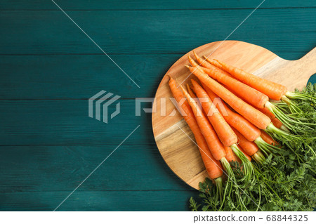 Cutting board with ripe carrots on wooden table Cutting board with ripe carrots on wooden table 68844325