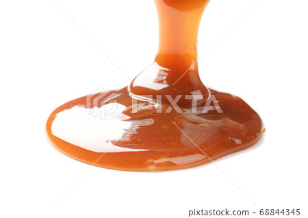 Pouring brown caramel isolated on white background 68844345