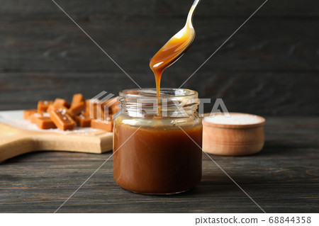 Glass jar with salted caramel and candies on Glass jar with salted caramel and candies on 68844358