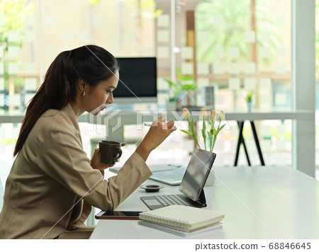 Side view of female working with digital tablet 68846645