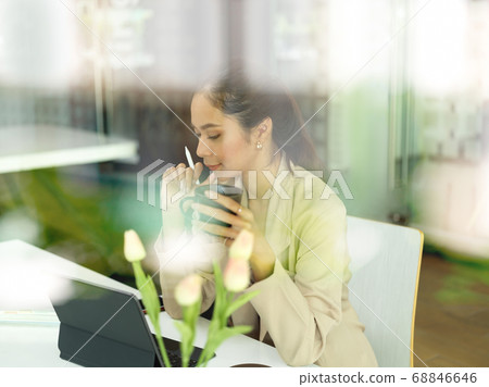 View through glass window of female office worker 68846646