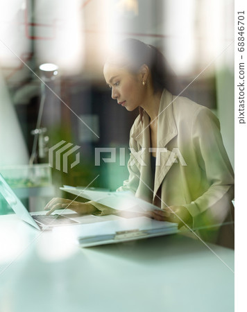 View through glass window of female concentrating 68846701