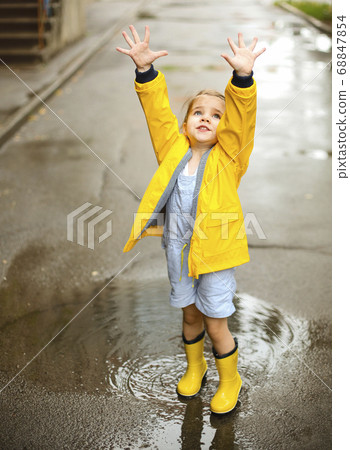 Little girl wearing yellow boots in rainy day Little girl wearing yellow boots in rainy day 68847854
