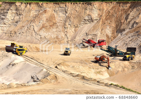 Wheel front-end loader loading sand into heavy dump truck at the opencast mining quarry Wheel front-end loader loading sand into heavy dump truck at the opencast mining quarry 68848660
