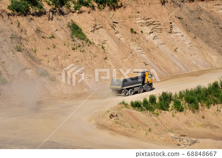 Dump truck transports sand in open pit mine.  68848667