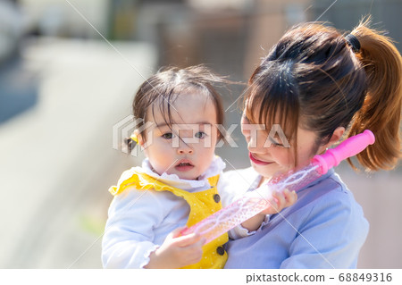 Cute little girl playing with playground equipment with mom Cute little girl playing with playground equipment with mom 68849316