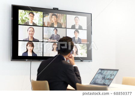 Man having a video conference towards the monitor 68850377