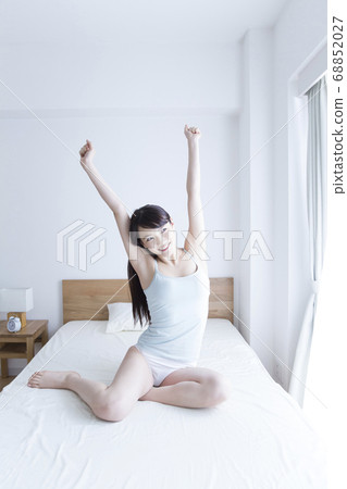 A woman stretching in bed 68852027