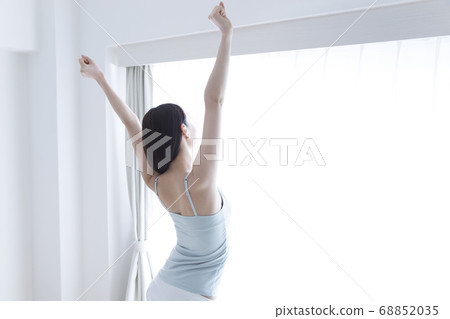A woman standing up and stretching 68852035