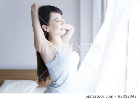 A woman standing up and stretching 68852042