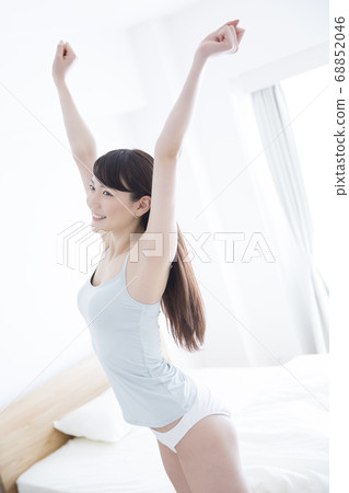 A woman standing up and stretching A woman standing up and stretching 68852046