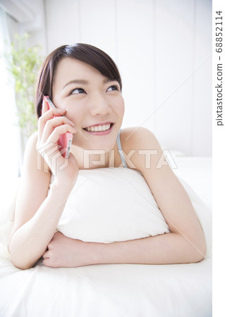 A woman who calls on the bed 68852114