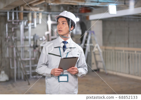 導演戴頭盔,看著平板電腦時檢查現場 導演戴頭盔,看著平板電腦時檢查現場 68852133