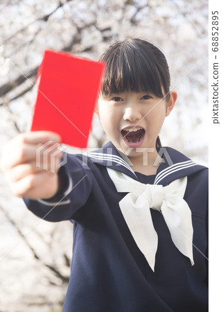 Female junior high school student with red card Female junior high school student with red card 68852895