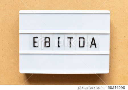 Lightbox with word EBITDA (abbreviation of earnings before interest, taxes, depreciation and amortization) on wood background 68854998
