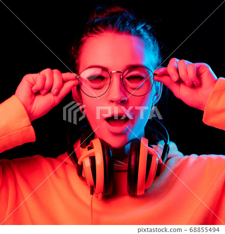 Caucasian woman's portrait isolated on studio background in neon light Caucasian woman's portrait isolated on studio background in neon light 68855494