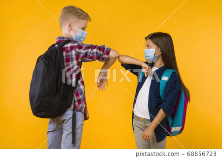 Two students standing together, bumping elbows at studio Two students standing together, bumping elbows at studio 68856723