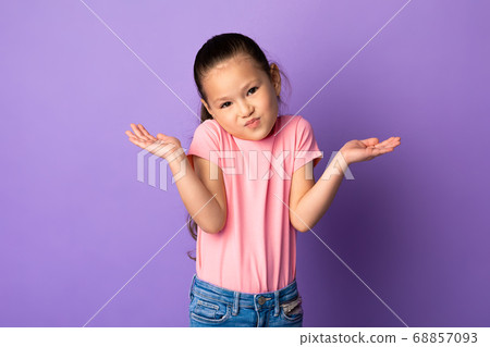 Confused puzzled asian kid shrugging at studio 68857093