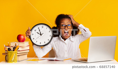 Shocked Schoolgirl Holding Clock Sitting At Laptop, Yellow Background, Panorama Shocked Schoolgirl Holding Clock Sitting At Laptop, Yellow Background, Panorama 68857140