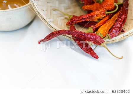 Dry red chilli pepper out of bamboo basket on whit cloth with copy space, food ingredient Dry red chilli pepper out of bamboo basket on whit cloth with copy space, food ingredient 68858403