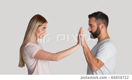 Resist domestic tyrant. Concentrated woman pushes male hands with hands, staring at each other menacingly 68858722